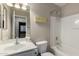 Well-lit bathroom featuring a tub with shower, toilet, vanity with sink, and decorative wall art at 16261 W Custer Ln, Surprise, AZ 85379