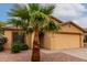 Close-up of desert home featuring a two-car garage, desert landscaping and tile roof at 16261 W Custer Ln, Surprise, AZ 85379
