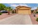 Front exterior view with a two-car garage and easy-care desert landscaping and palm trees at 16261 W Custer Ln, Surprise, AZ 85379