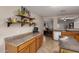 Bright kitchen with stainless steel appliances, tile floors, and breakfast bar pass-through to living room at 16261 W Custer Ln, Surprise, AZ 85379