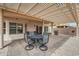 Backyard with a shaded dining space, complete with a grill and landscaped patio area at 16427 W Labyrinth Ln, Surprise, AZ 85374