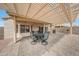 Shaded backyard patio features a dining table, grill and stone flooring at 16427 W Labyrinth Ln, Surprise, AZ 85374