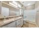 Bright bathroom featuring a double vanity with granite countertops and a glass-enclosed shower at 16427 W Labyrinth Ln, Surprise, AZ 85374