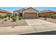 Charming home featuring a two car garage and desert landscaping at 16427 W Labyrinth Ln, Surprise, AZ 85374