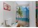 A cozy bathroom featuring a toilet with decorative accents and a shower with a vibrant palm tree curtain at 1645 W Baseline Rd # 2125, Mesa, AZ 85202