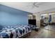 Bright bedroom with a large window, bed, and a TV stand against blue accent wall at 1645 W Baseline Rd # 2125, Mesa, AZ 85202