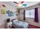 Cozy bedroom featuring a twin bed, natural light from the window, and a ceiling fan at 16820 N 152Nd Ln, Surprise, AZ 85374