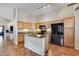 Spacious kitchen featuring granite countertops, a modern island, wood cabinets, and black appliances at 16820 N 152Nd Ln, Surprise, AZ 85374