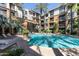 Resort-style community pool surrounded by lounge chairs, landscaping, and building exterior at 1701 E Colter St # 488, Phoenix, AZ 85016