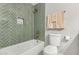 Bathroom boasts stylish green tiled shower over tub with a recessed shower caddy at 1920 N Cavalier Dr, Tempe, AZ 85288
