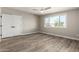 Inviting bedroom featuring wood-look floors, a double door closet, and a large window for natural light at 1920 N Cavalier Dr, Tempe, AZ 85288