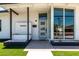 Charming modern home with green lawn, crisp white paint, elegant dark trim, and minimalist desert landscaping at 1920 N Cavalier Dr, Tempe, AZ 85288