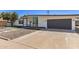 Modern single-story home with a gray garage door, concrete driveway, and desert landscaping at 1920 N Cavalier Dr, Tempe, AZ 85288