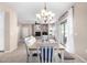 Open-concept dining room with view of living room and fireplace, illuminated by an elegant chandelier at 19700 N 76Th St # 1151, Scottsdale, AZ 85255