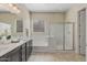 Well-lit bathroom featuring dual sinks, a soaking tub, and a separate glass-enclosed shower at 20233 E Maya Rd, Queen Creek, AZ 85142