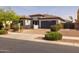 Attractive single-level home with a landscaped front yard, brick driveway, and attached two-car garage at 20233 E Maya Rd, Queen Creek, AZ 85142