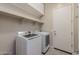 Well-equipped laundry room featuring modern washer, dryer, shelving, and convenient storage cabinets at 20233 E Maya Rd, Queen Creek, AZ 85142