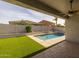 Backyard with pool, covered patio, and lush artificial turf for easy maintenance at 20233 E Maya Rd, Queen Creek, AZ 85142