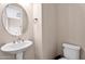 Bathroom featuring a modern pedestal sink, round mirror, and neutral walls at 2090 S Dorsey Ln # 1037, Tempe, AZ 85282