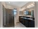 This bathroom features dual sinks, a glass enclosed shower and granite countertops with dark wood cabinets at 2090 S Dorsey Ln # 1037, Tempe, AZ 85282