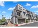 Contemporary three-story building featuring gray facade, balconies, and glass garage doors at 2090 S Dorsey Ln # 1037, Tempe, AZ 85282