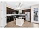 Stylish kitchen with dark wood cabinets, stainless steel appliances, granite countertops, and center island at 2090 S Dorsey Ln # 1037, Tempe, AZ 85282