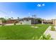 This backyard features new artificial turf and mature landscaping at 2325 E Delgado St, Phoenix, AZ 85022