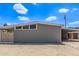 Side view of a single-story home featuring a carport and desert landscaping under a bright, sunny sky at 2325 E Delgado St, Phoenix, AZ 85022