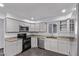 Bright kitchen featuring modern appliances, white cabinets, granite countertops, and sleek tile flooring at 2325 E Delgado St, Phoenix, AZ 85022