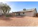 Backyard featuring a covered patio area, low-maintenance gravel, and artificial turf lawn at 2345 E Isabella Ave, Mesa, AZ 85204