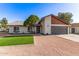 Charming single-story home with gravel landscaping, green lawn, and a two-car attached garage at 2345 E Isabella Ave, Mesa, AZ 85204