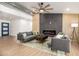 Modern living room featuring stylish sofas, ceiling fan, wood accent wall, and a decorative fireplace at 2345 E Isabella Ave, Mesa, AZ 85204