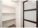 Walk-in pantry with ample shelving and wooden, frosted sliding door at 2345 E Isabella Ave, Mesa, AZ 85204
