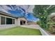 Well-maintained backyard with manicured lawn, mature tree, and block wall for added privacy at 23497 S 212Th St, Queen Creek, AZ 85142
