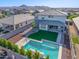 Stunning aerial view of a backyard featuring a sparkling pool, covered patio, and artificial turf, ideal for outdoor living at 25725 S 230Th St, Queen Creek, AZ 85142