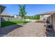 Landscaped backyard featuring artificial turf, gravel, and a charming young tree at 25725 S 230Th St, Queen Creek, AZ 85142