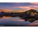 Scenic view of the community clubhouse reflecting on the lake, framed by a vibrant sunset at 25725 S 230Th St, Queen Creek, AZ 85142