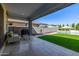 Inviting covered patio with comfortable seating, a grill, and views of the pool and lush backyard at 25725 S 230Th St, Queen Creek, AZ 85142