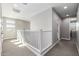 Bright hallway with white banister and neutral color scheme provides an airy, spacious feel at 25725 S 230Th St, Queen Creek, AZ 85142