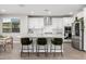 Bright kitchen boasts white cabinetry, stainless appliances, subway tile backsplash, and an eat-in island with barstool seating at 25725 S 230Th St, Queen Creek, AZ 85142