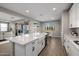 This bright kitchen shows white cabinets, stainless appliances, and a large island with wood-look tile floors at 25725 S 230Th St, Queen Creek, AZ 85142