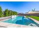Inviting pool with a soothing waterfall feature, artificial grass and large patio umbrella at 25725 S 230Th St, Queen Creek, AZ 85142