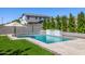 Refreshing pool area with a modern waterfall feature and lush artificial grass at 25725 S 230Th St, Queen Creek, AZ 85142