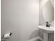 Powder room featuring a pedestal sink, round mirror, and modern fixtures at 25725 S 230Th St, Queen Creek, AZ 85142