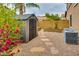 Well-maintained backyard features a storage shed, greenery, and desert landscaping, ideal for relaxation and storage at 26926 N 55Th Ln, Phoenix, AZ 85083