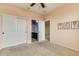 Neutral bedroom with closet and ensuite bathroom entrance, ceiling fan, and warm beige carpet at 26926 N 55Th Ln, Phoenix, AZ 85083