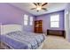 Cozy bedroom features a ceiling fan, natural light from the windows, and a wooden bookshelf at 26926 N 55Th Ln, Phoenix, AZ 85083