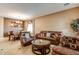 Inviting living room flows into dining area, featuring tile floors, leather furniture, and plenty of natural light at 26926 N 55Th Ln, Phoenix, AZ 85083