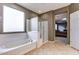 Bathroom featuring a bathtub under the window and a glass-door shower next to the entry at 26926 N 55Th Ln, Phoenix, AZ 85083