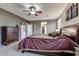 Spacious main bedroom with carpeted floors, ceiling fan, and access to the walk-in closet and bathroom at 26926 N 55Th Ln, Phoenix, AZ 85083